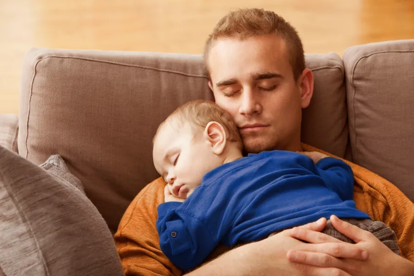 Hombre durmiendo con su bebé sobre su pecho