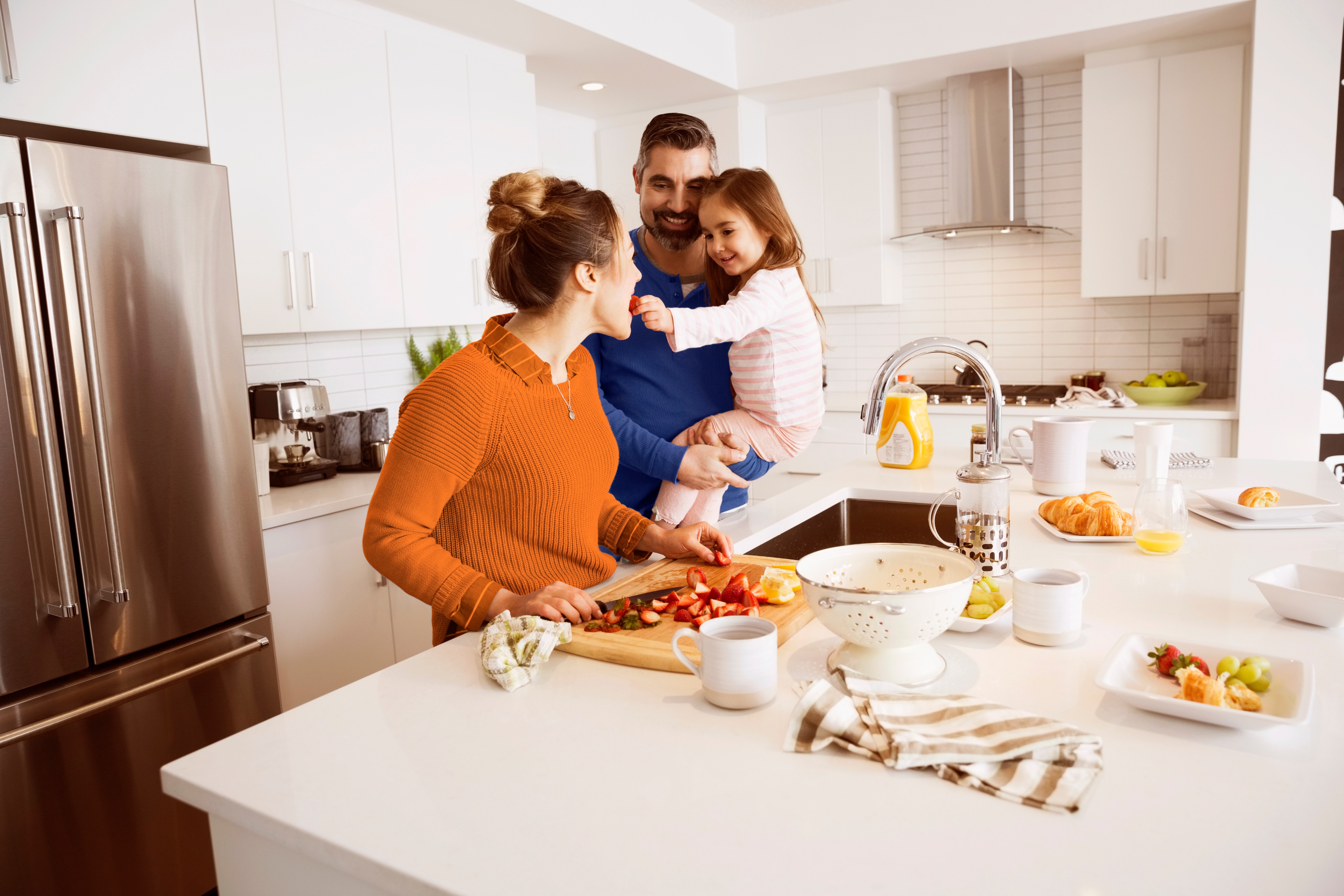 En la imagen familia compartiendo con su pequeña hija mientras cocinan