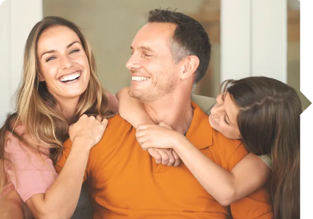 Hombre siendo abrazado por su esposa e hija